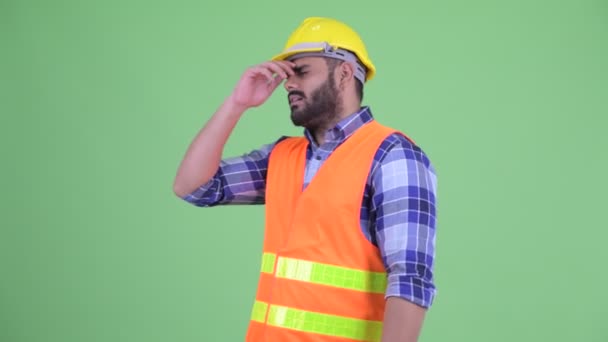 ストレスの多い若い太りすぎのひげを生やしたインド人男性建設労働者は悪いニュースを得る — ストック動画
