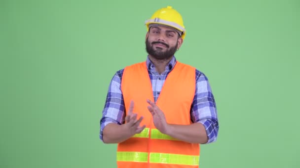 Feliz joven sobrepeso barbudo hombre indio trabajador de la construcción aplaudiendo de la mano — Vídeos de Stock