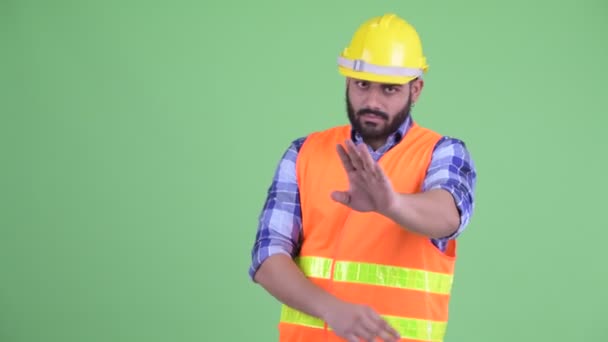 Súlyos fiatal túlsúlyos szakállas indiai ember építőmunkás-val megáll gesztus — Stock videók