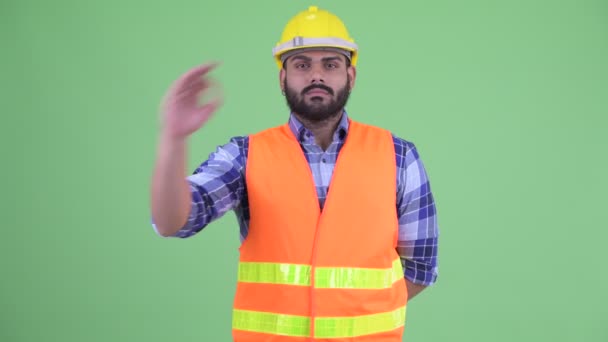幸せな若い太りすぎひげを生やしたインド人男性建設労働者はOKサインを持つ — ストック動画