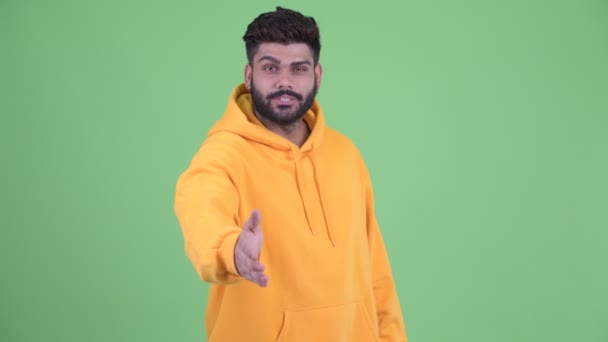 Happy young overweight bearded Indian man giving handshake — Stock Video