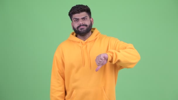 Zły młody nadwaga Brodaty Indyjski człowiek dając kciuki w dół — Wideo stockowe