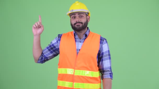 Щасливий молодий надмірна вага Бородаті Індійська людина будівельний працівник вказуючи вгору — стокове відео