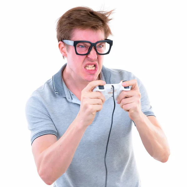 ゲームをプレイし、怒って見て大きな眼鏡を持つ面白い若いオタクの男 — ストック写真