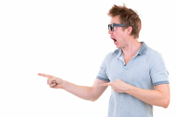 Funny young nerd man with big eyeglasses pointing finger and showing something Stock Image