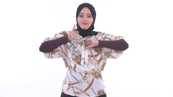 Jovem muçulmana africana confusa escolhendo entre polegares para cima e polegares para baixo — Vídeo de Stock