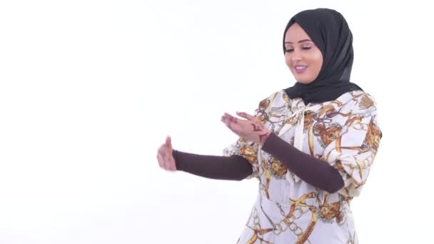 Ευτυχισμένη νεαρή αφρικανική μουσουλμανική γυναίκα δείχνει κάτι και δίνοντας τους αντίχειρες επάνω — Αρχείο Βίντεο
