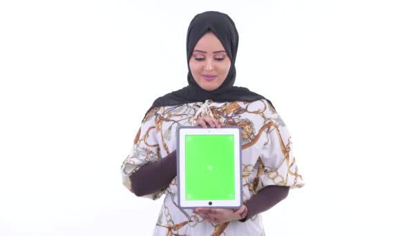 Ευτυχής νεαρή αφρικανική μουσουλμανική γυναίκα που δείχνει το ψηφιακό δισκίο και αναζητούν έκπληκτος — Αρχείο Βίντεο