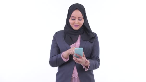 電話を使用して、良いニュースを得る幸せな若いアフリカのイスラム教徒のビジネスウーマン — ストック動画