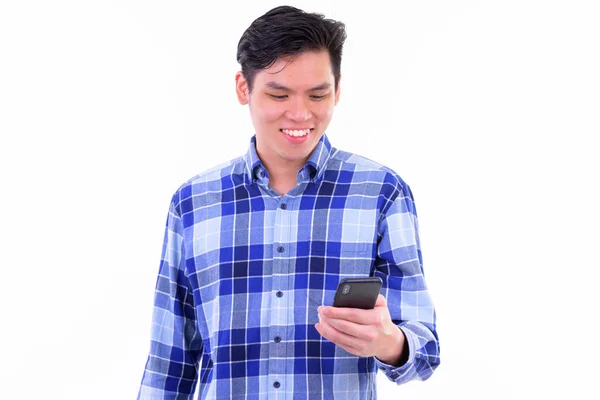 Szczęśliwy młody przystojny Asian Hipster mężczyzna za pomocą telefon — Zdjęcie stockowe