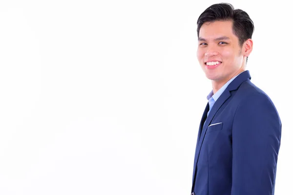 Profile view of happy young handsome Asian businessman looking at camera — Stock Photo, Image