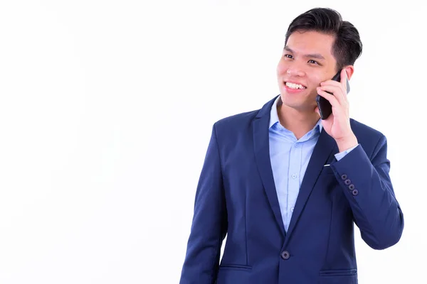 Feliz joven empresario asiático pensando mientras habla por teléfono — Foto de Stock