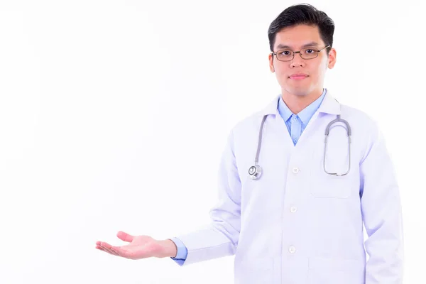 Joven guapo asiático hombre médico mostrando algo — Foto de Stock