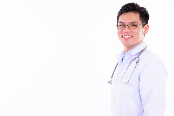 Perfil vista de feliz jovem asiático homem médico olhando para a câmera — Fotografia de Stock