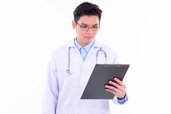 Joven guapo asiático hombre médico leyendo en portapapeles —  Fotos de Stock