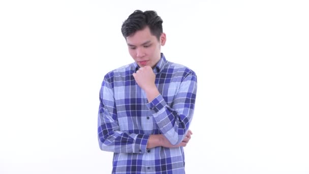 Stresli genç Asya hipster adam düşünme ve aşağı bakıyor — Stok video