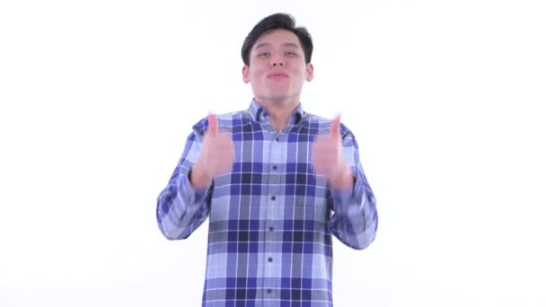Счастливый молодой азиатский хипстер показывает большие пальцы вверх и выглядит взволнованным — стоковое видео