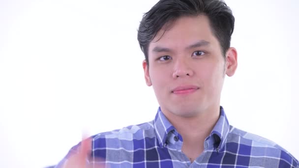 Face of happy young Asian hipster man giving thumbs up — Stock Video