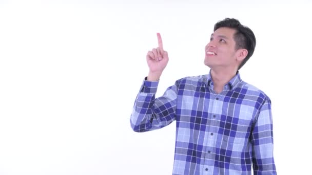 Feliz joven asiático hipster hombre pensando y señalando hacia arriba — Vídeo de stock