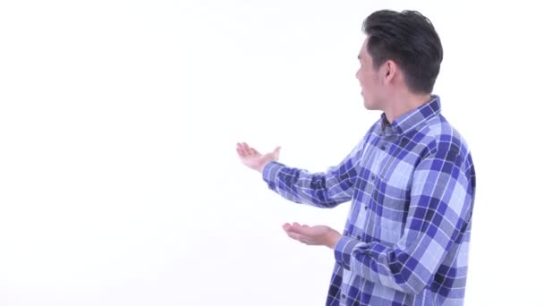 Lycklig ung asiatisk hipster man visar på ryggen — Stockvideo