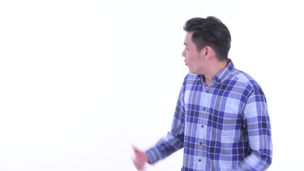 Glücklich junge asiatische Hipster Mann zeigt auf den Rücken und schauen überrascht — Stockvideo