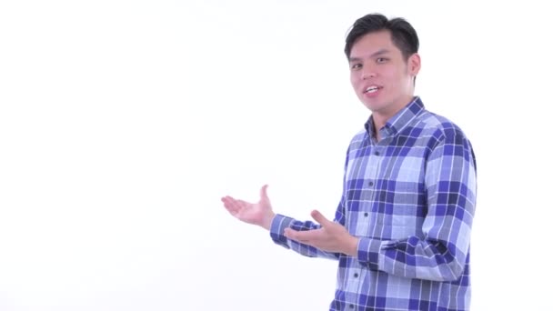 Glücklich junge asiatische Hipster Mann reden, während zeigen, um den Rücken — Stockvideo