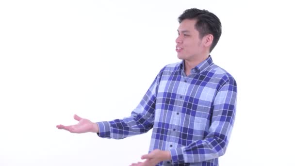 Счастливый молодой азиатский хипстер говорит, показывая что-то — стоковое видео