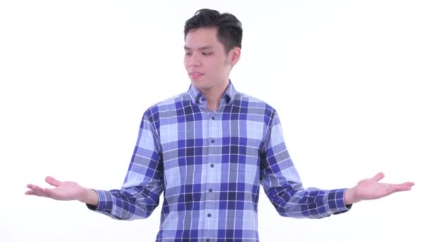 Feliz joven asiático hipster hombre comparando algo — Vídeo de stock