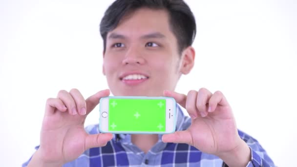 Обличчя щасливих молодих азіатських хіпстера людини мислення під час показу телефону — стокове відео
