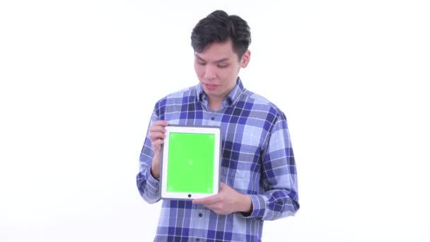 Heureux jeune asiatique hipster homme penser tout en montrant tablette numérique — Video