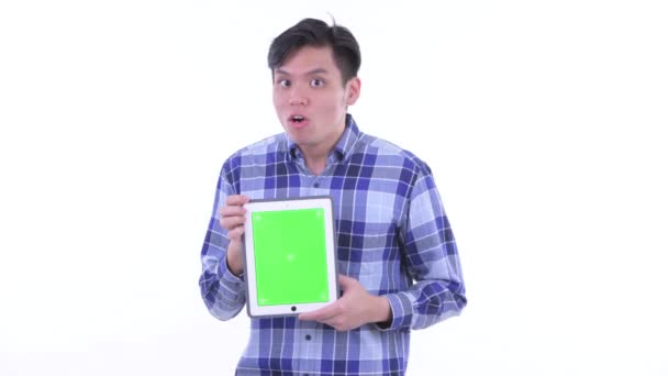 Happy young Asian hipster man showing digital tablet and looking surprised — Stock Video