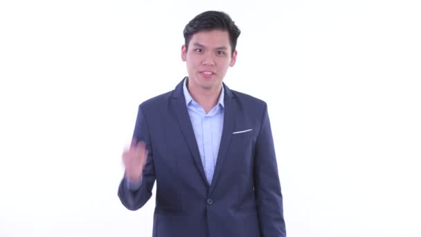 Happy young Asian businessman pointing at camera — Stock Video