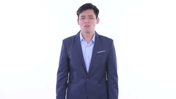 Грустный молодой азиатский бизнесмен подает большие пальцы — стоковое видео