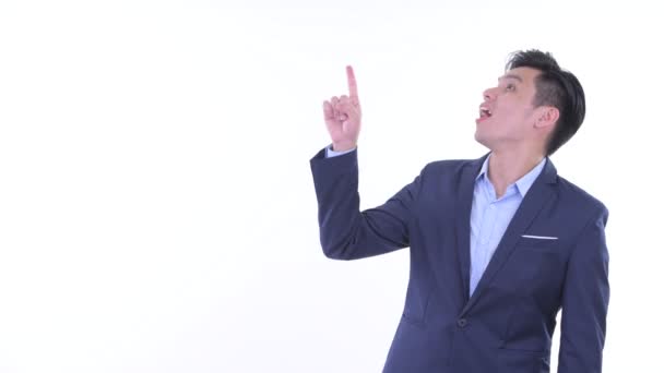 Happy young Asian businessman pointing up and looking excited — Stock Video