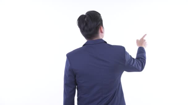 Vista trasera de un joven empresario asiático señalando con el dedo y dirigiendo — Vídeos de Stock