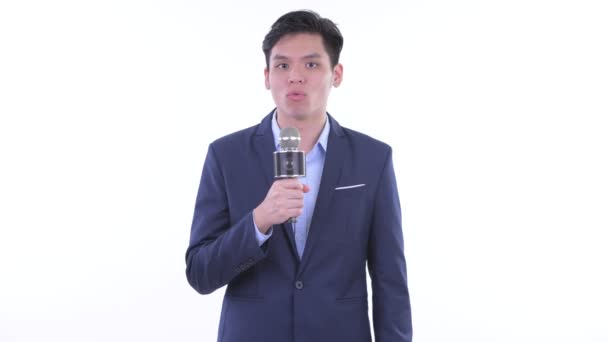 Gelukkig jonge Aziatische zakenman als nieuwslezer met behulp van microfoon — Stockvideo