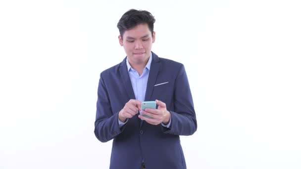 Feliz joven asiático hombre de negocios utilizando el teléfono y recibiendo buenas noticias — Vídeo de stock