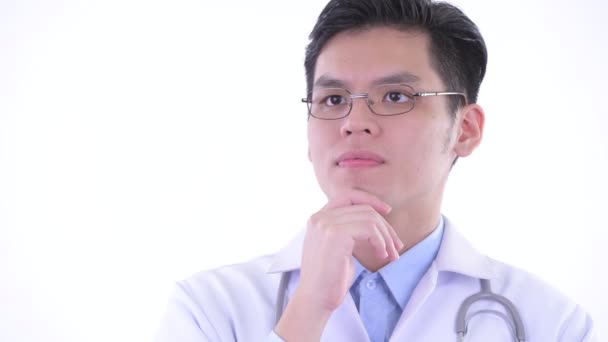 面对快乐的年轻亚洲男子医生思考和仰望 — 图库视频影像