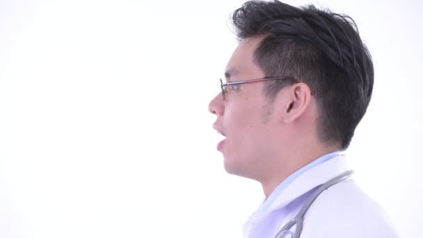 Closeup profile view of happy young Asian man doctor smiling — Stock Video