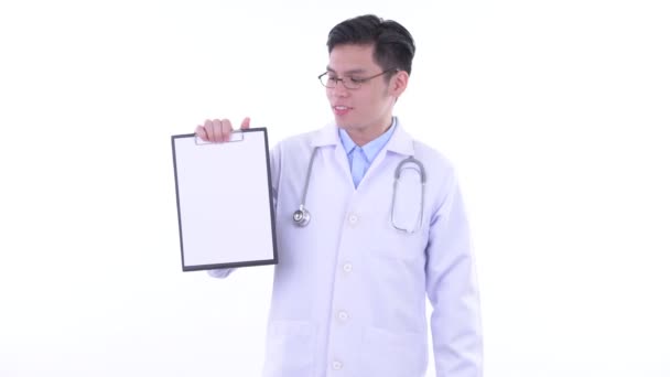 Ευτυχισμένος νέος Ασιάτης/ισσα άνθρωπος γιατρός δείχνει πρόχειρο και δίνοντας αντίχειρες επάνω — Αρχείο Βίντεο
