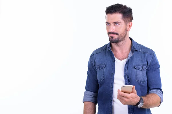 Jonge bebaarde hipster man denken tijdens het gebruik van de telefoon — Stockfoto