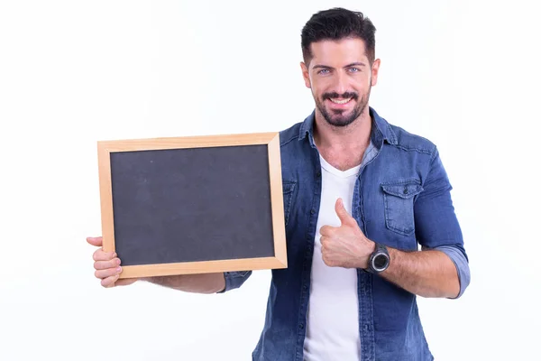 Feliz jovem barbudo hipster homem mostrando blackboard e dando polegares para cima — Fotografia de Stock