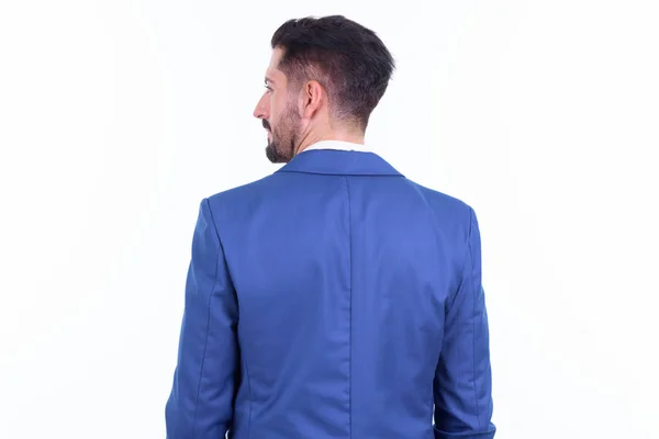 Rear view of young bearded businessman looking over shoulder — Stock Photo, Image
