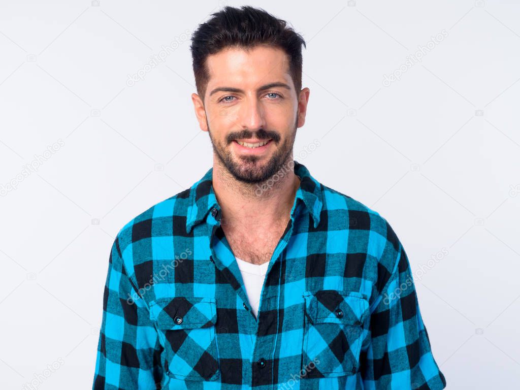 Face of happy young handsome bearded hipster man smiling