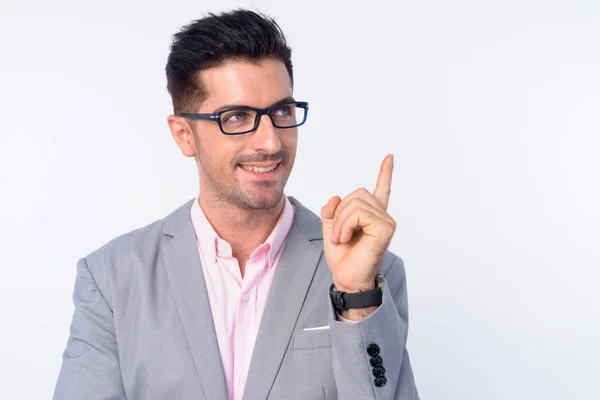 Rostro de joven hombre de negocios guapo feliz con anteojos pensando y señalando hacia arriba —  Fotos de Stock