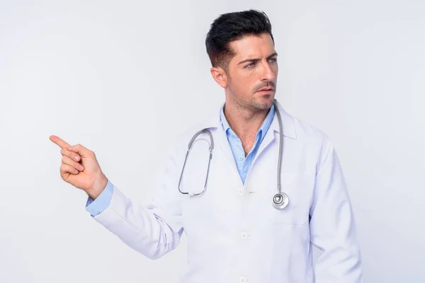 Genç yakışıklı adam doktor işaret parmak ve uzağa bakarak Portresi — Stok fotoğraf