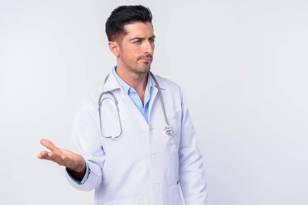 Portrait of confused young handsome man doctor with arms raised — Stock Photo, Image