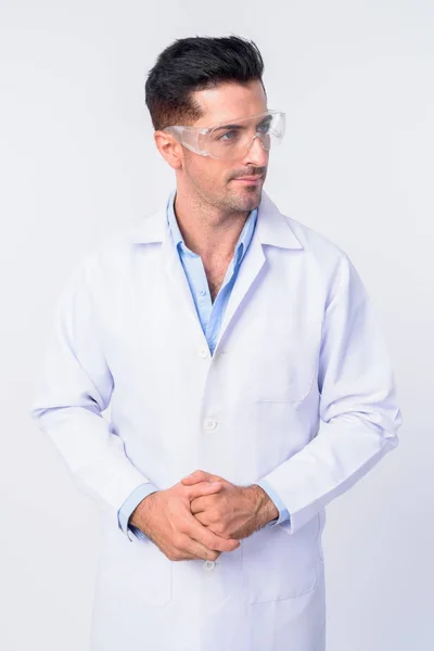 Giovane bel dottore uomo con occhiali protettivi pensando — Foto Stock
