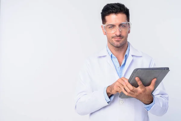 Joven hombre guapo médico con gafas protectoras usando tableta digital —  Fotos de Stock