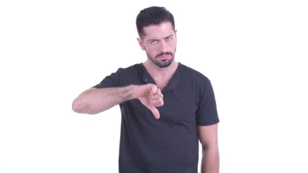 Злой молодой бородатый мужчина, показывающий пальцами вниз — стоковое видео